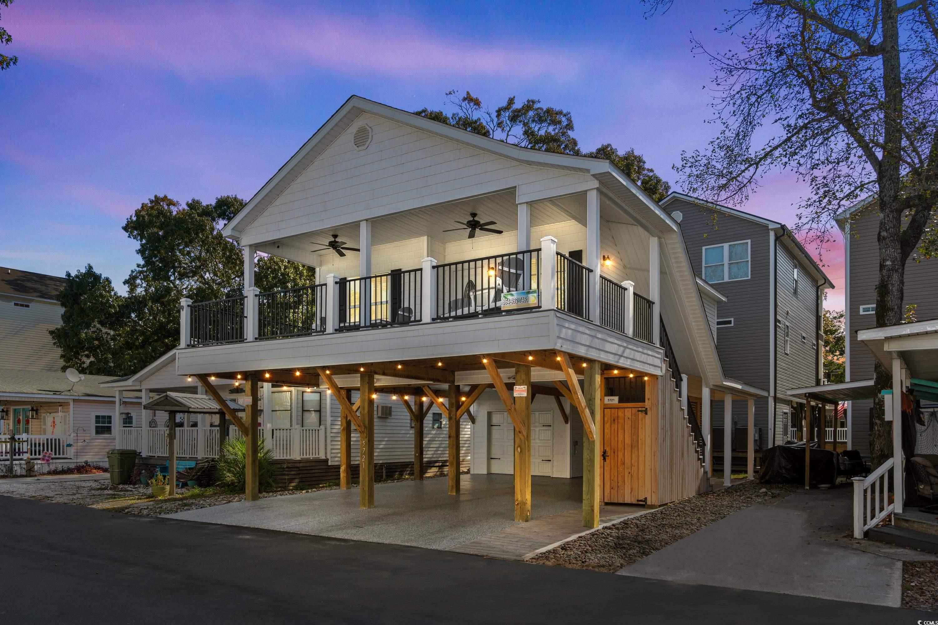 View of front of house featuring ceiling fan, a ba