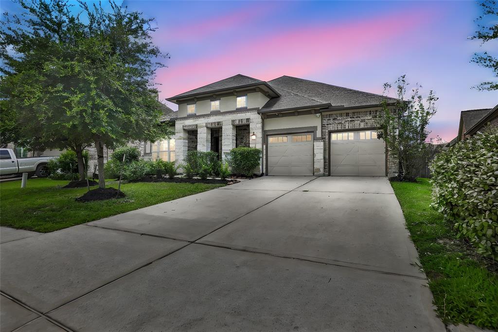 a front view of a house with yard and green space