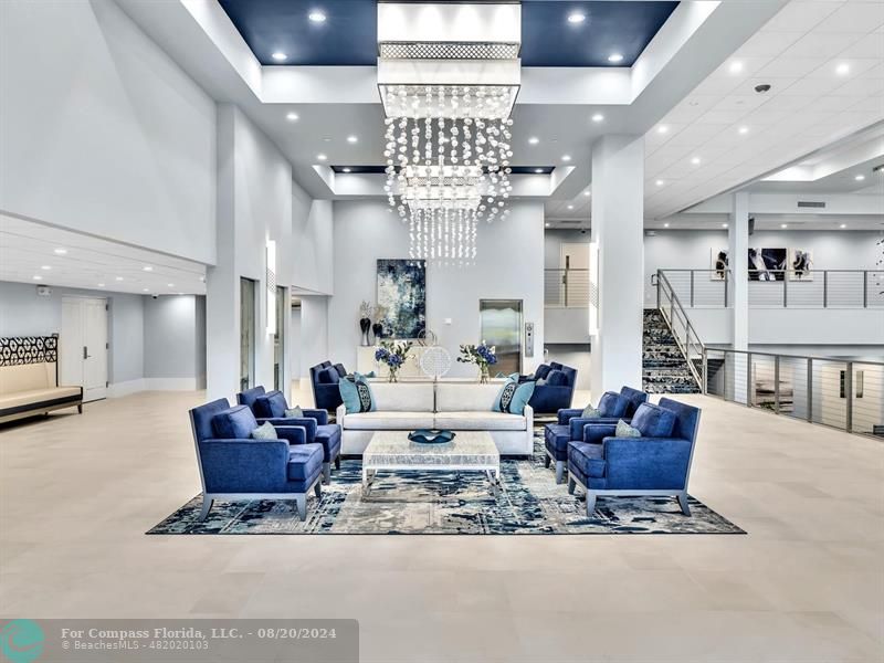 a living room with furniture a chandelier and a dining table