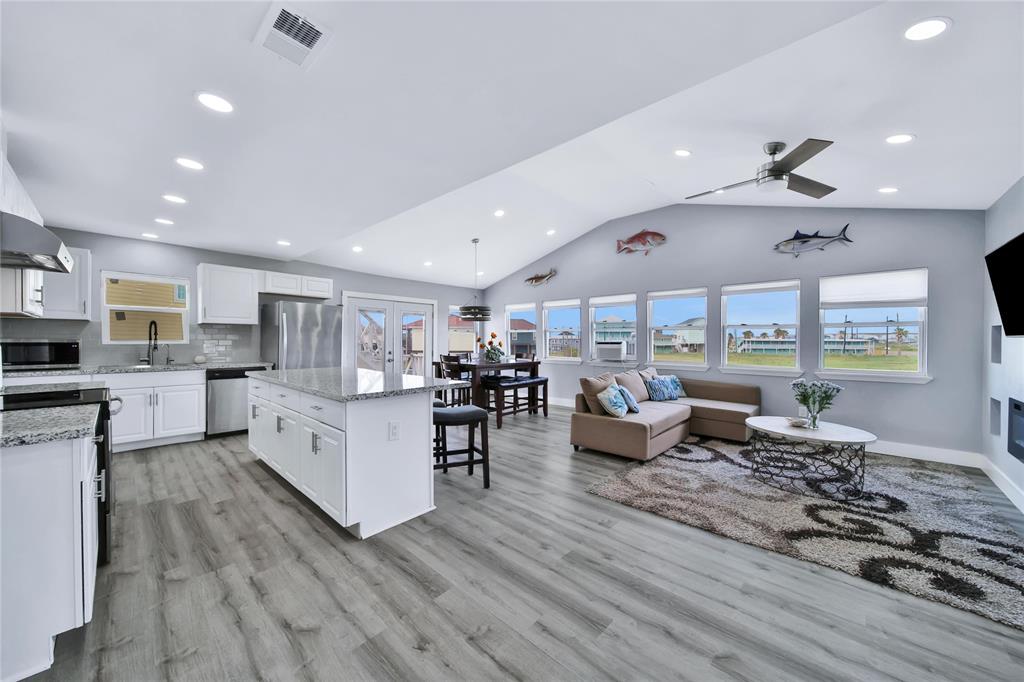 a living room with furniture kitchen view and a large window