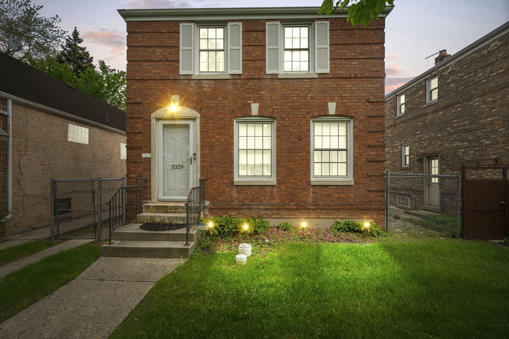 a view of a house with brick walls and a yard with table and chairs