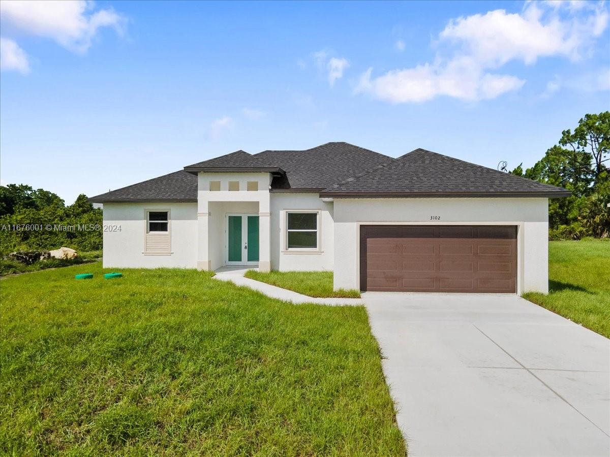 a front view of house with yard and garage