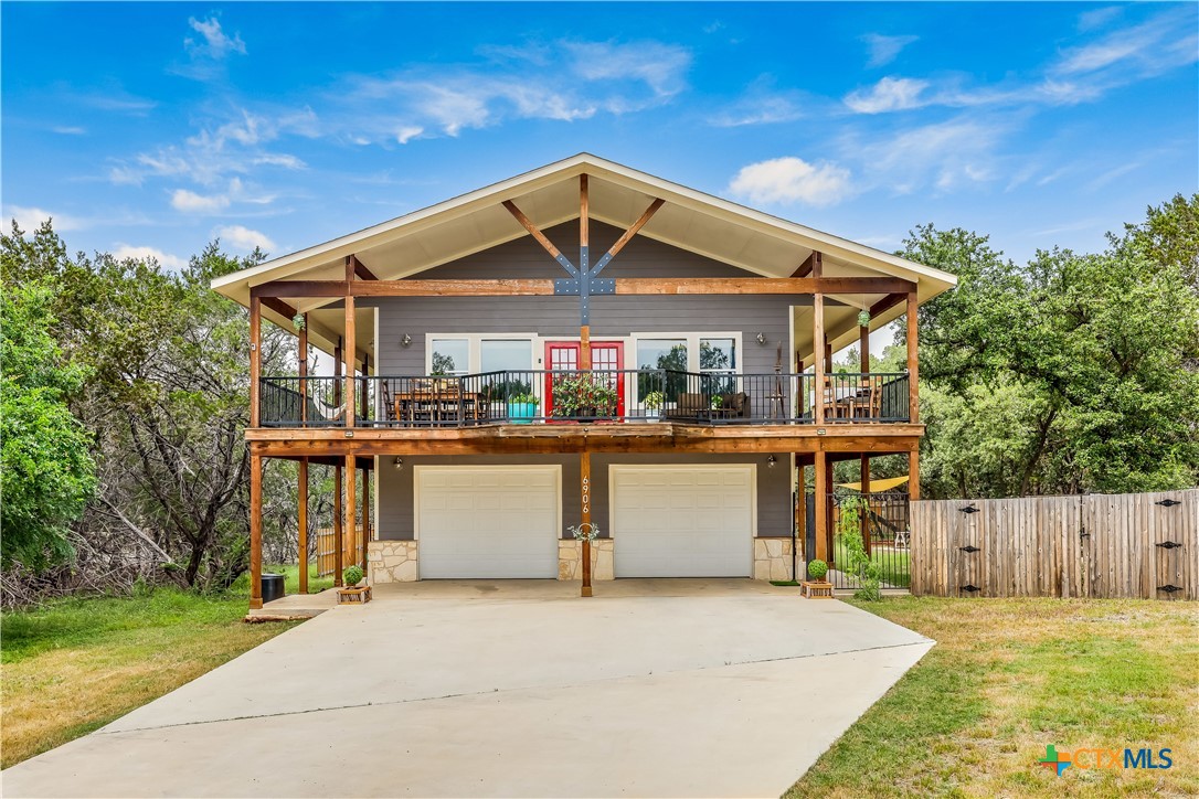 a front view of house with yard and trees in the background