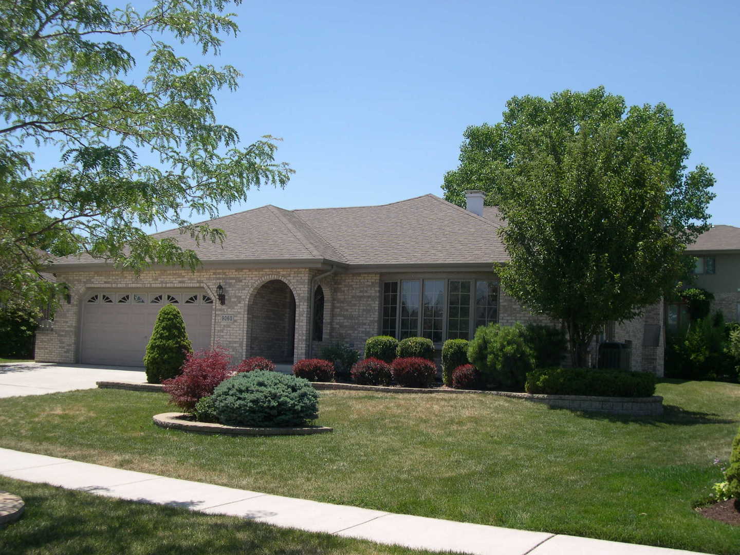 a view of a house with a yard and potted plants