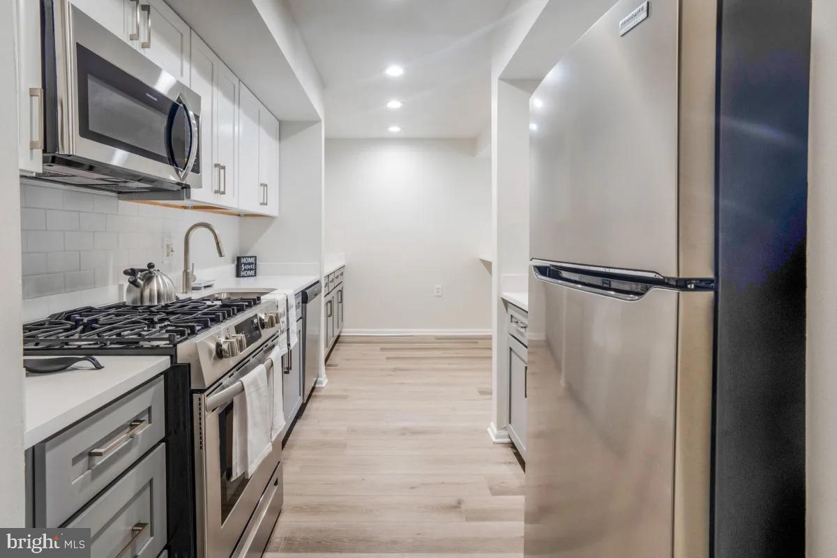 a kitchen with stainless steel appliances granite countertop a stove and a refrigerator