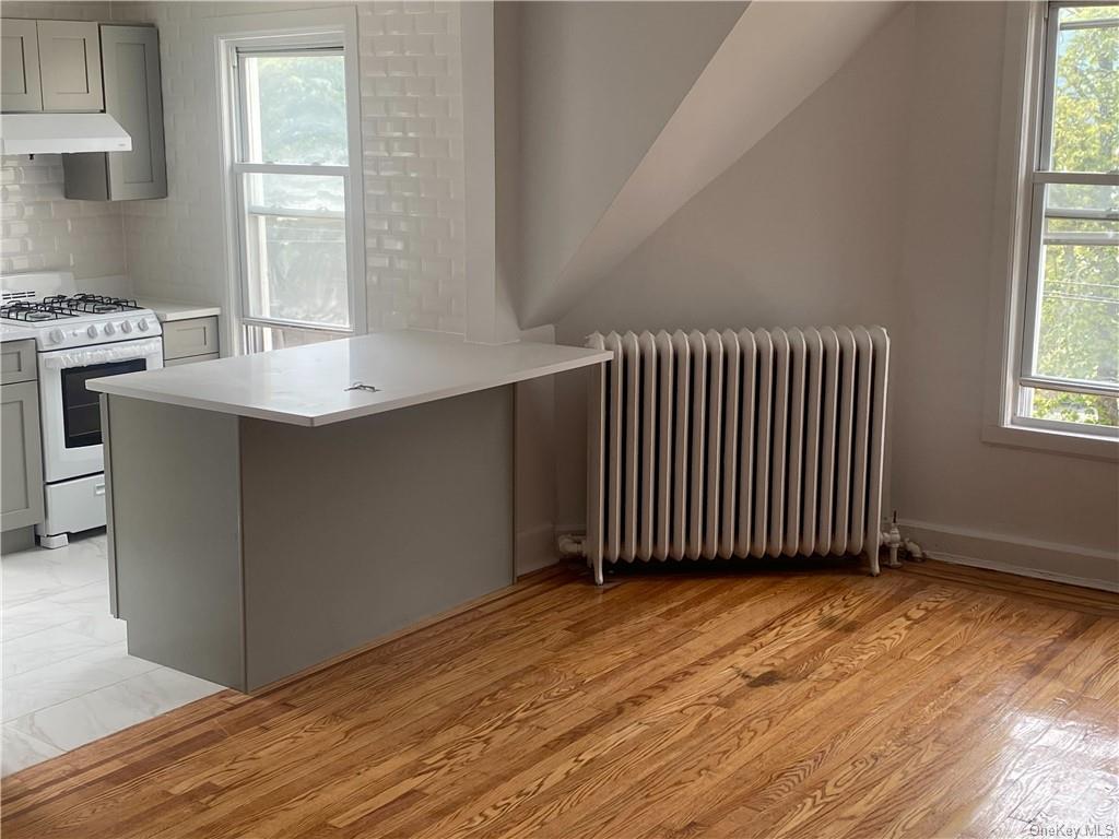 a view of a kitchen with wooden floor and a window