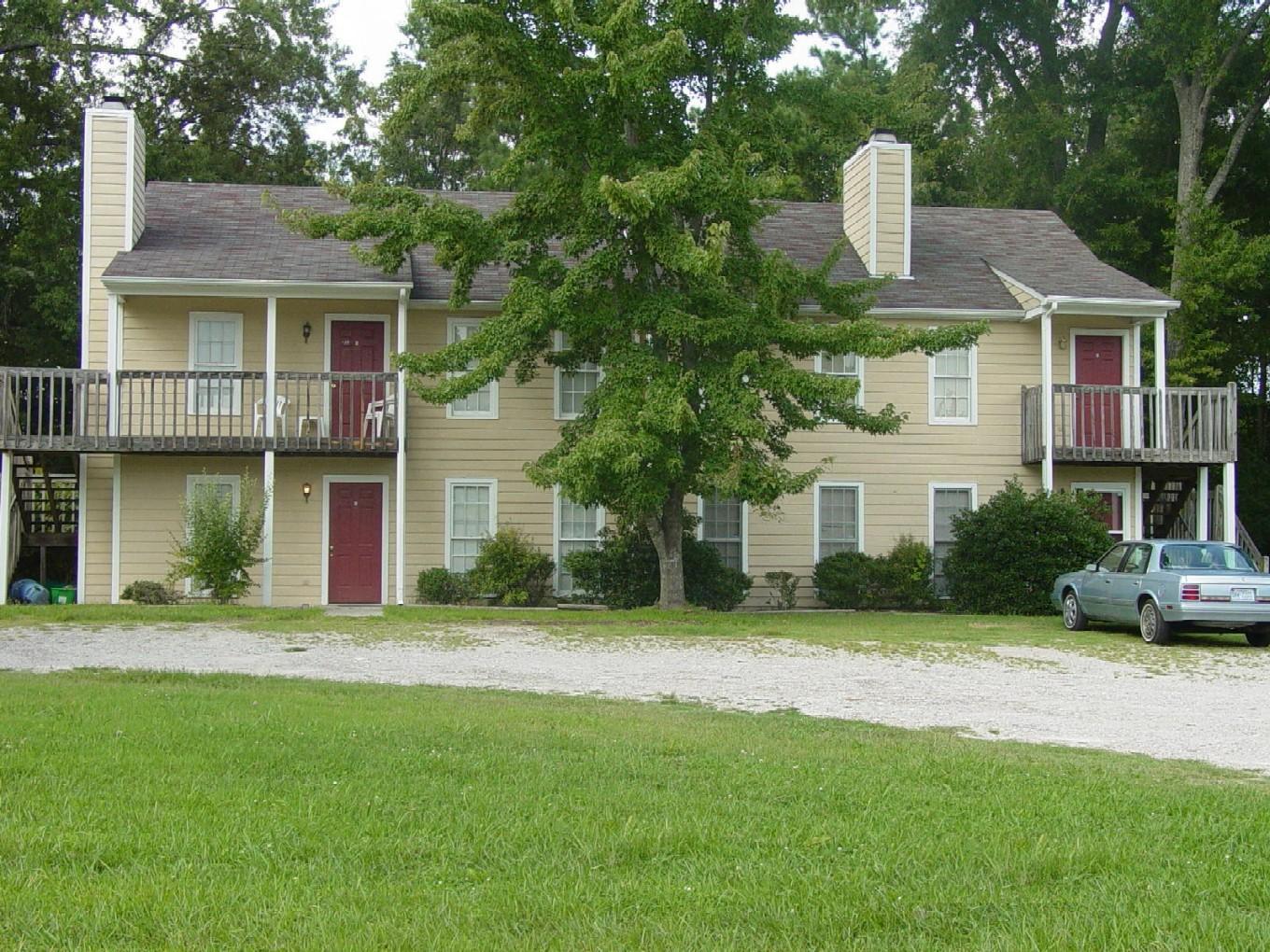 a front view of a house with a yard and trees