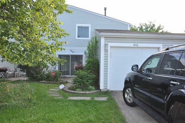 a view of a house with a car parked in a yard