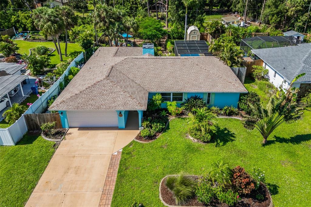 a aerial view of a house with a yard and potted plants