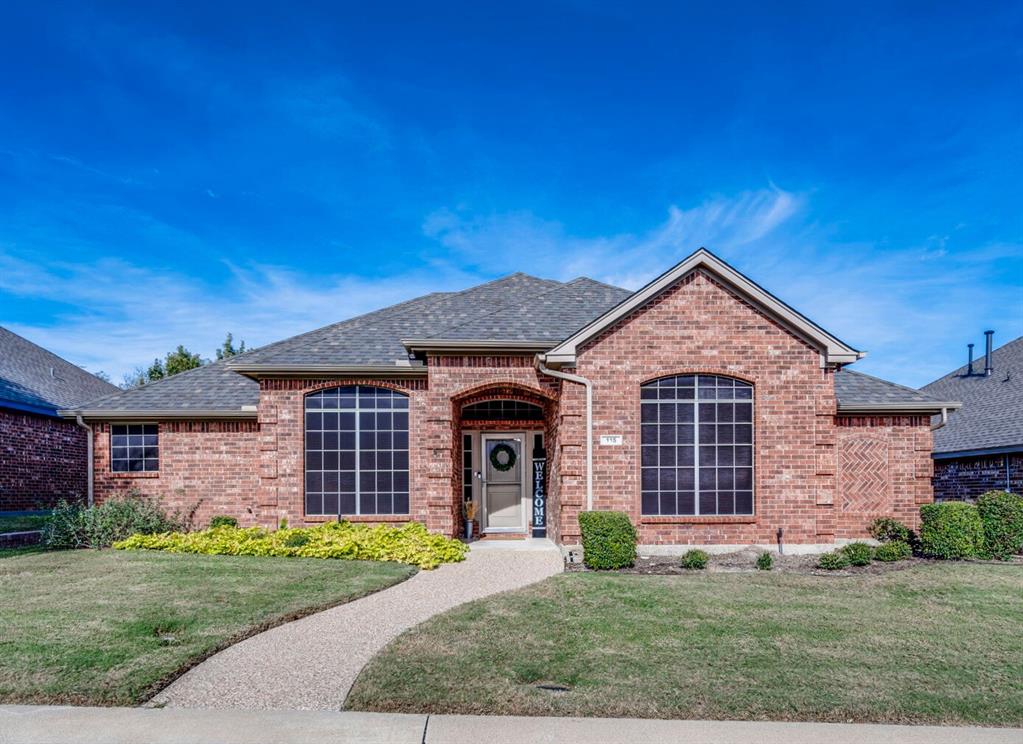 front view of a brick house with a yard