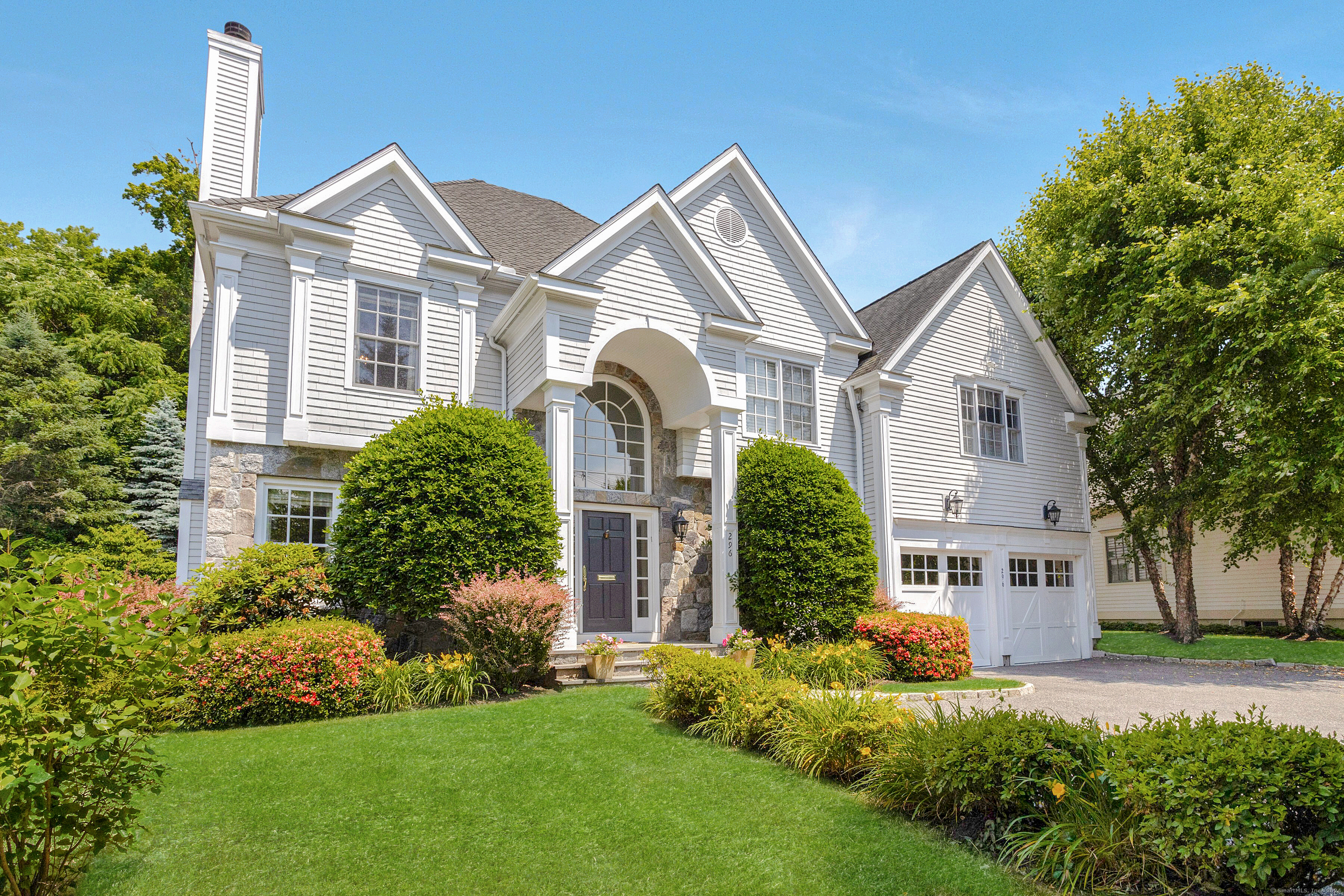 a front view of a house with a yard and potted plants