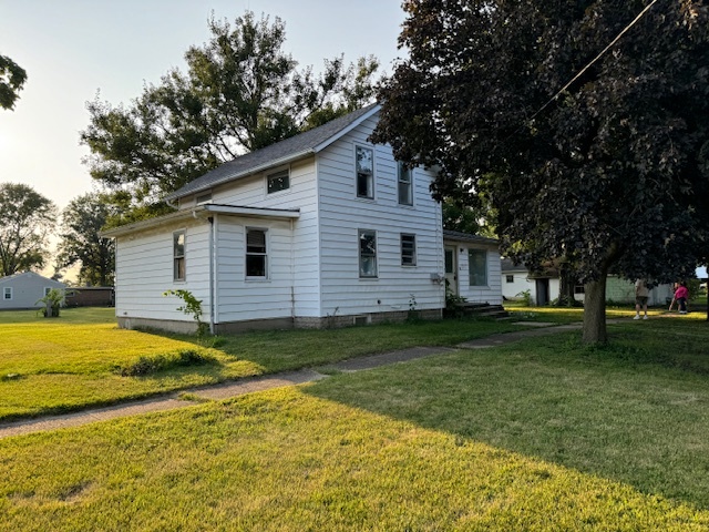 a view of a house with a yard patio and tree