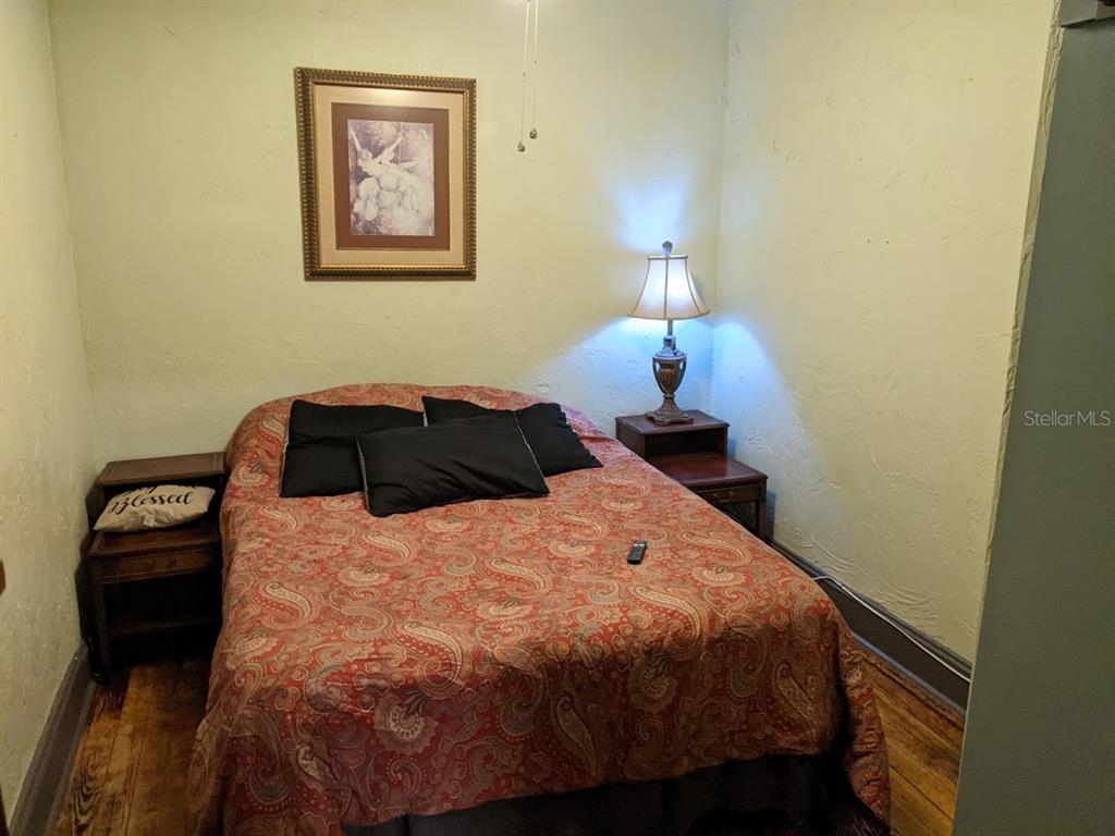 a bedroom with a bed and a lamp on dresser