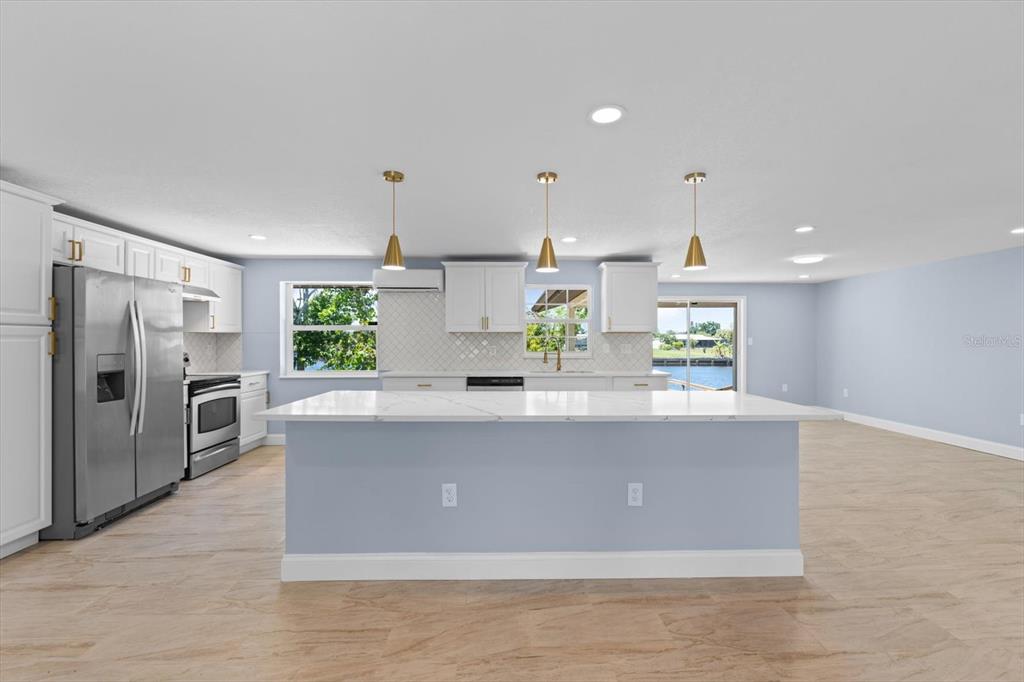 a view of kitchen with stainless steel appliances granite countertop refrigerator sink and stove