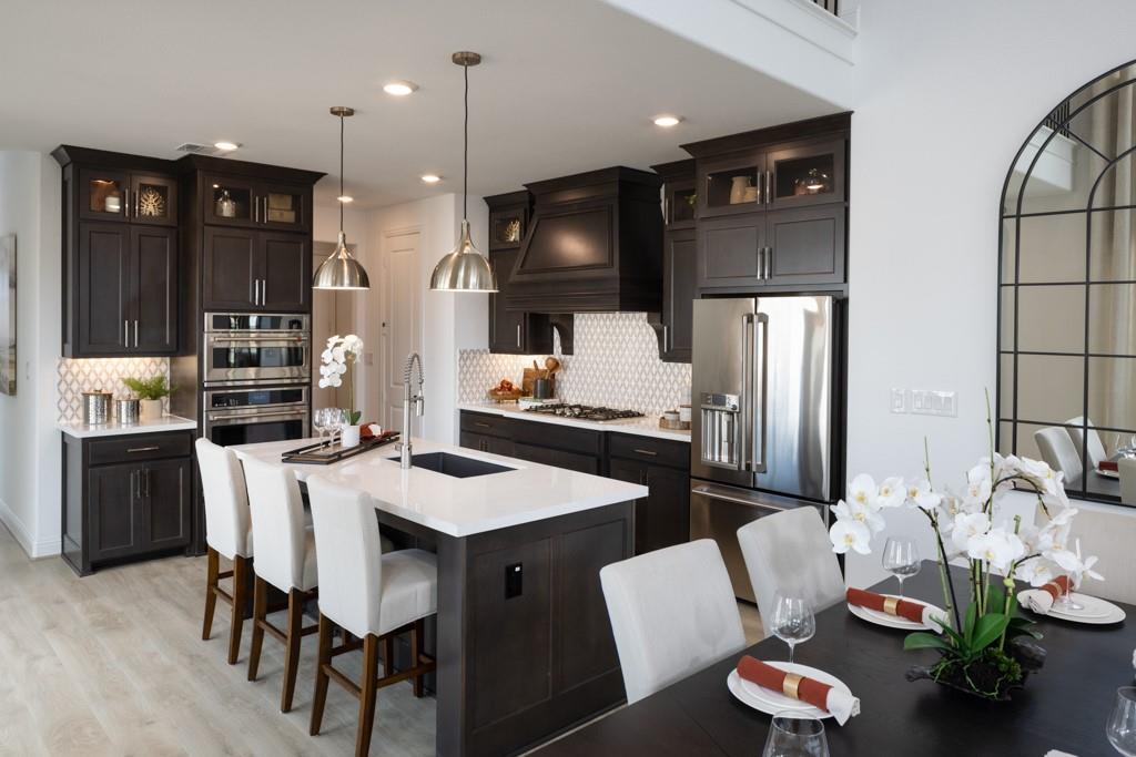 a kitchen with stainless steel appliances kitchen island granite countertop a dining table and chairs