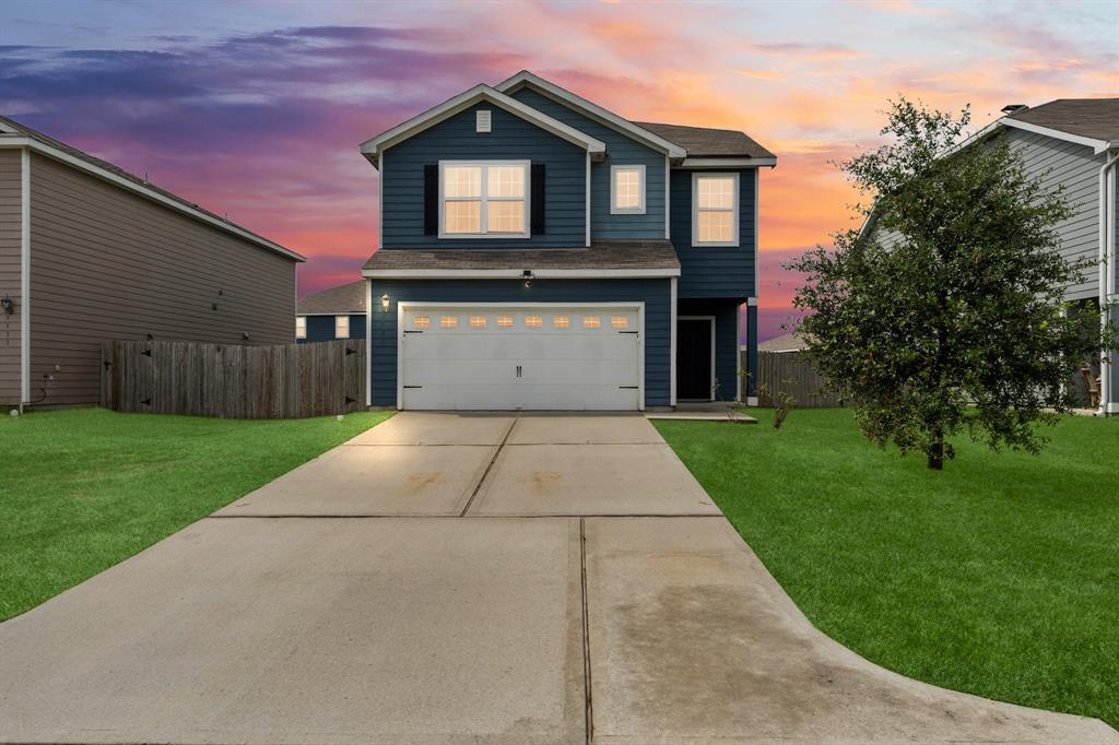 a front view of a house with a yard and garage