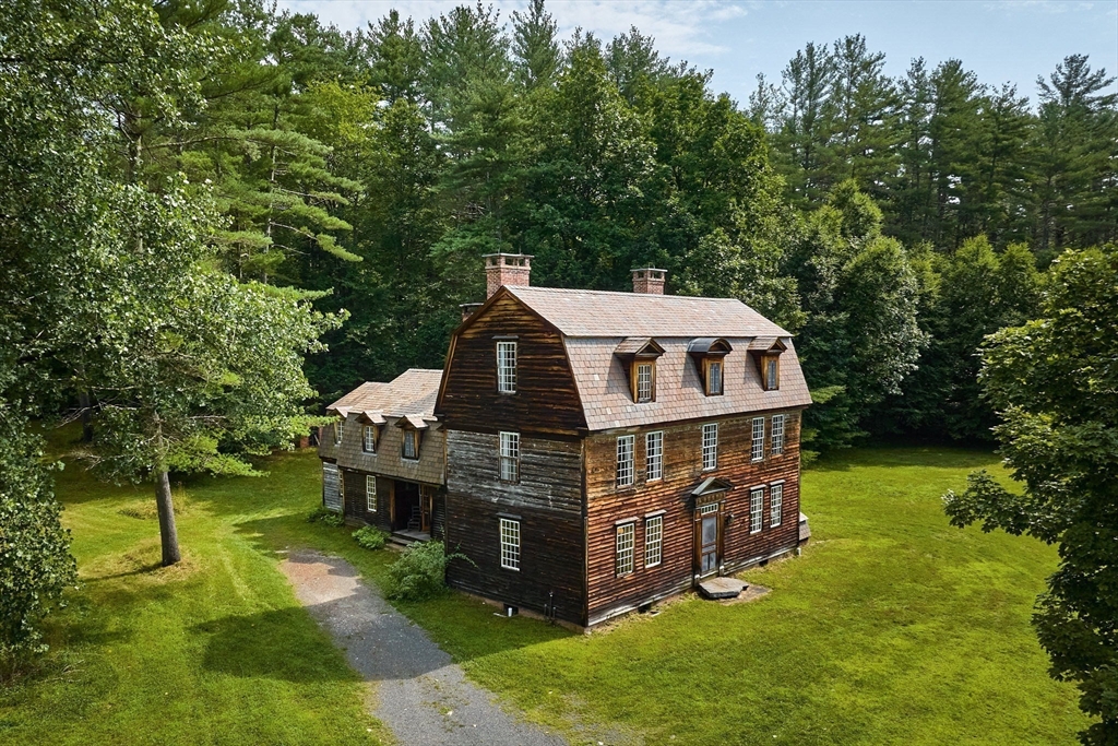 aerial view of a house with a big yard and large trees