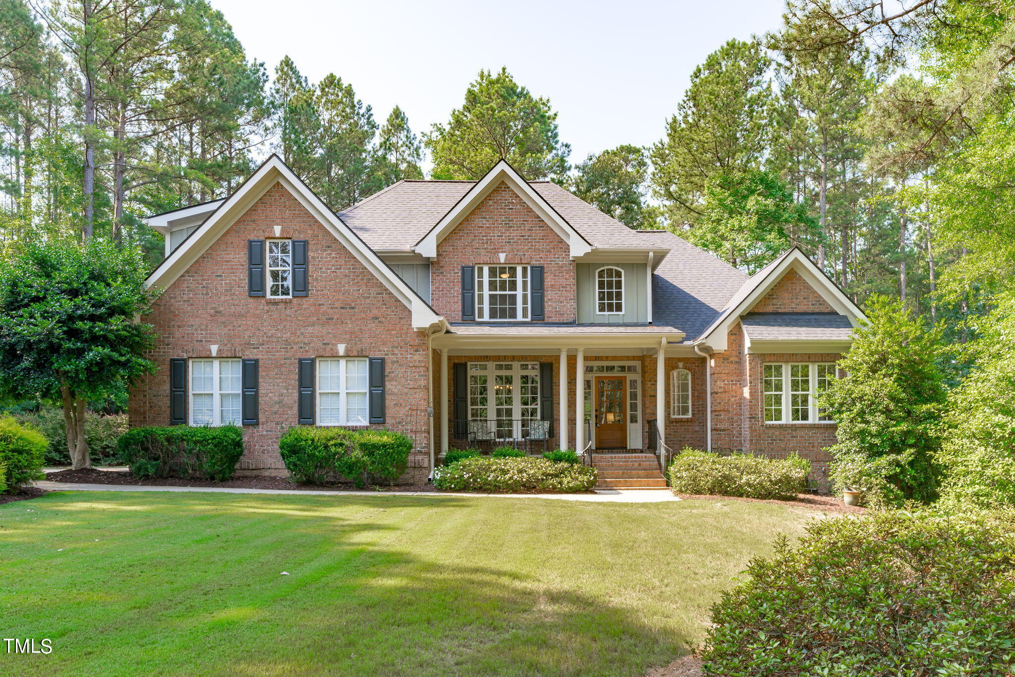 a front view of a house with yard and green space