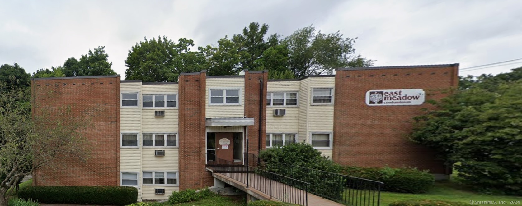 a view of building with yard and trees in the background