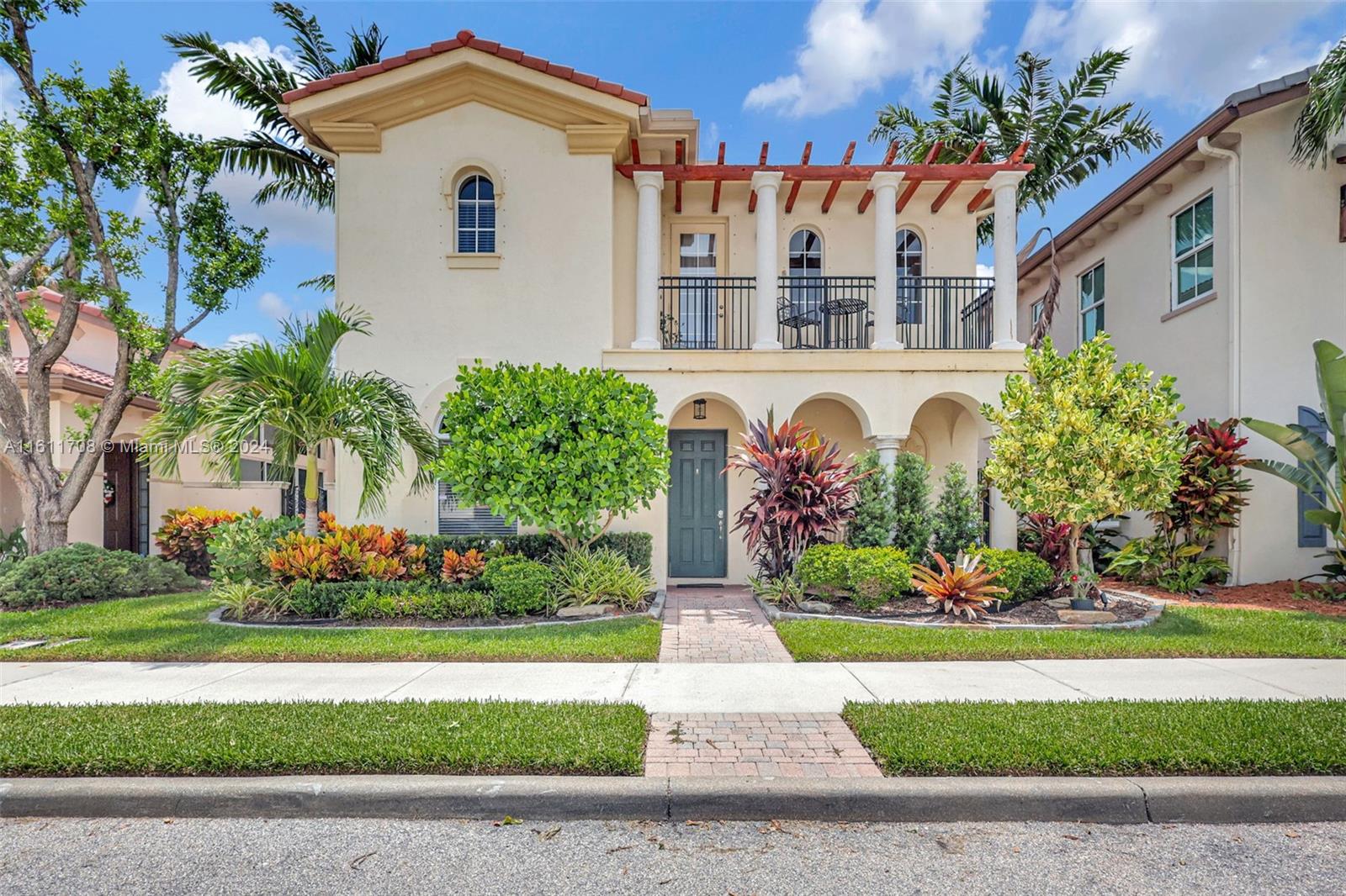 a front view of a house with a yard and potted plants