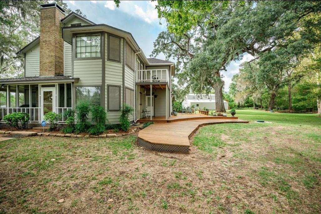 a view of a house with backyard and trees