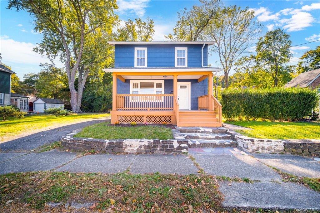 View of front property featuring a porch and a front yard