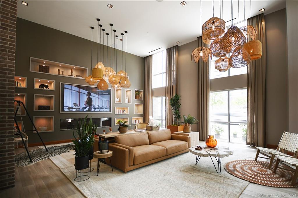 a living room with furniture a chandelier and a large window