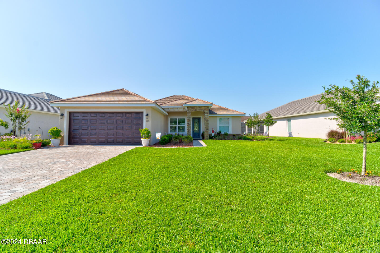 a front view of a house with a garden and yard