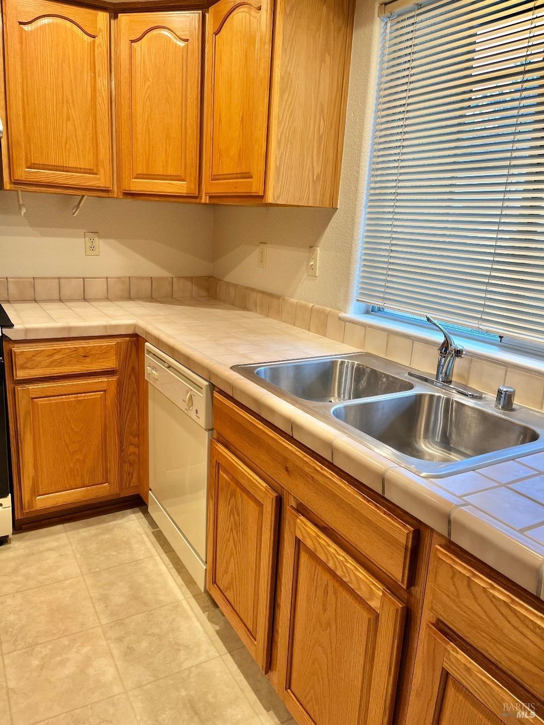 a kitchen with stainless steel appliances granite countertop a sink and dishwasher next to a window