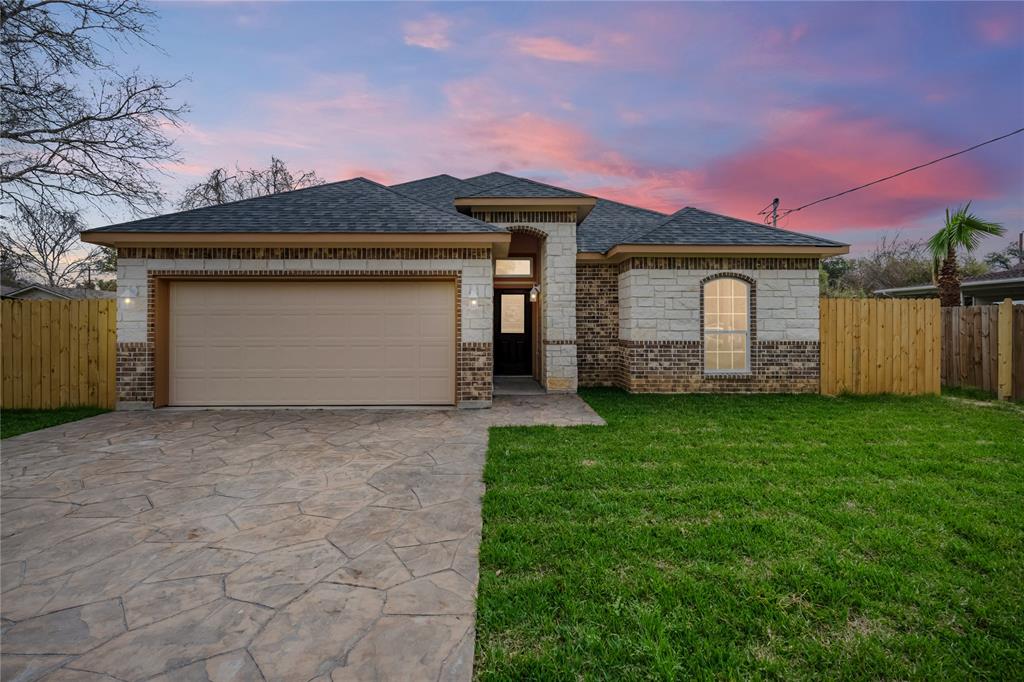 a front view of a house with a garden and garage