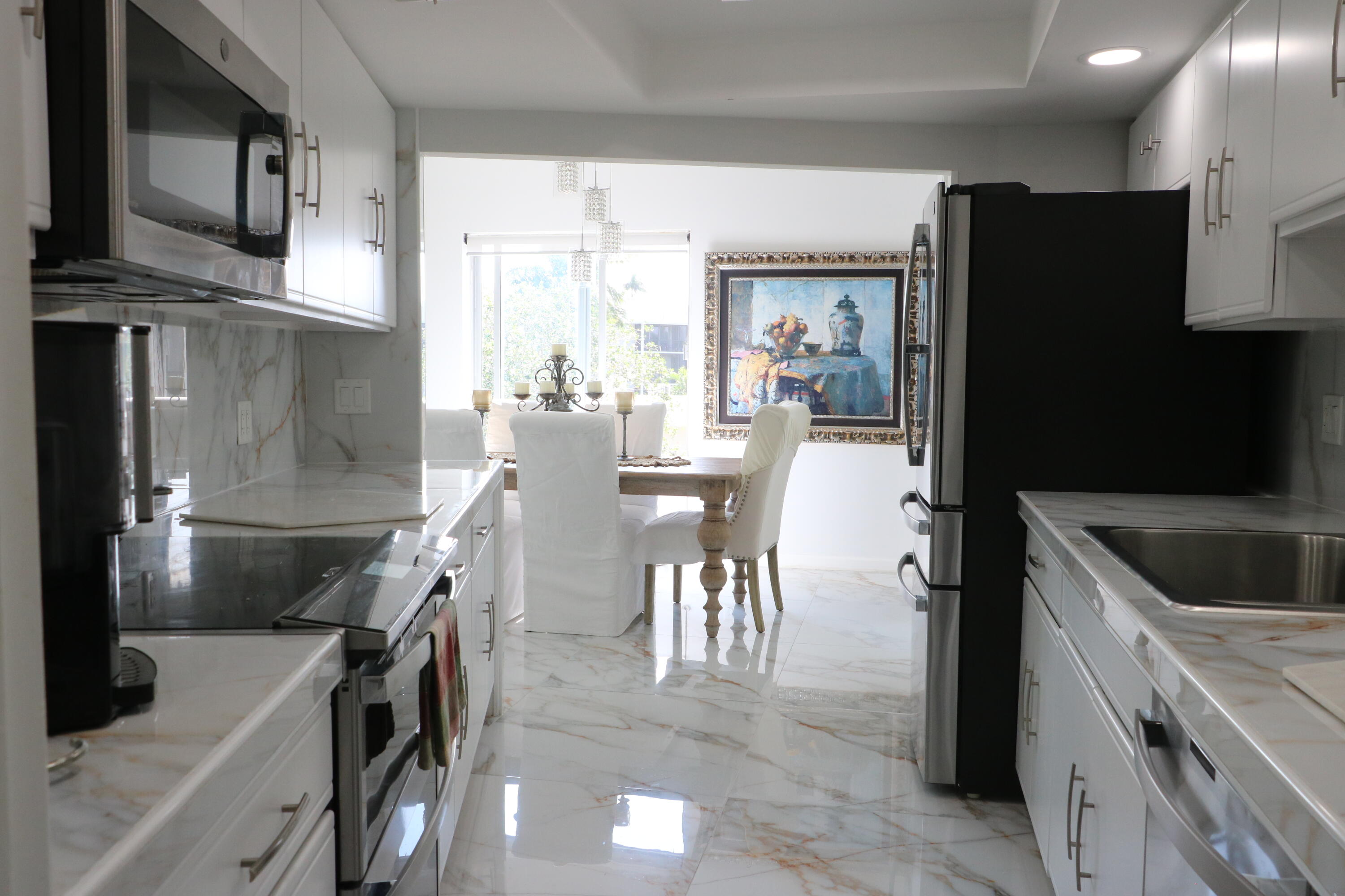 a kitchen with stainless steel appliances kitchen island granite countertop a refrigerator and a stove top oven