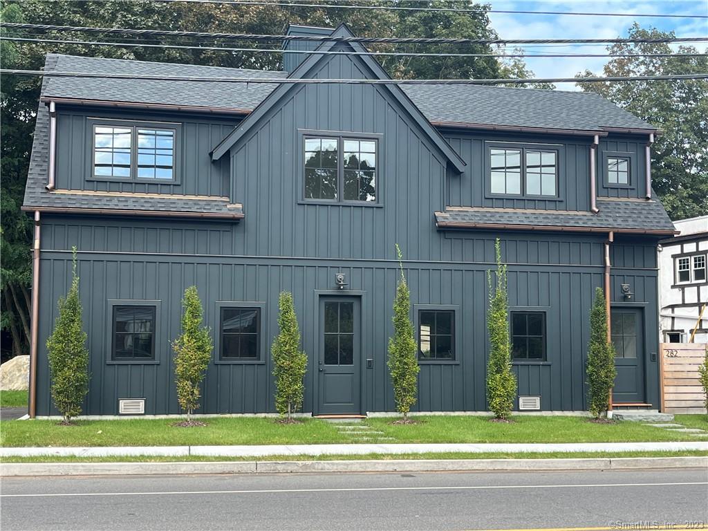 a view of a brick house with a windows and a yard with plants