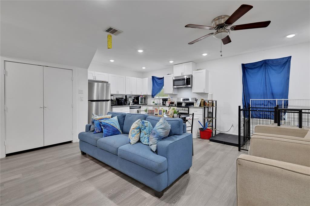 a living room with stainless steel appliances kitchen island furniture and a view of kitchen