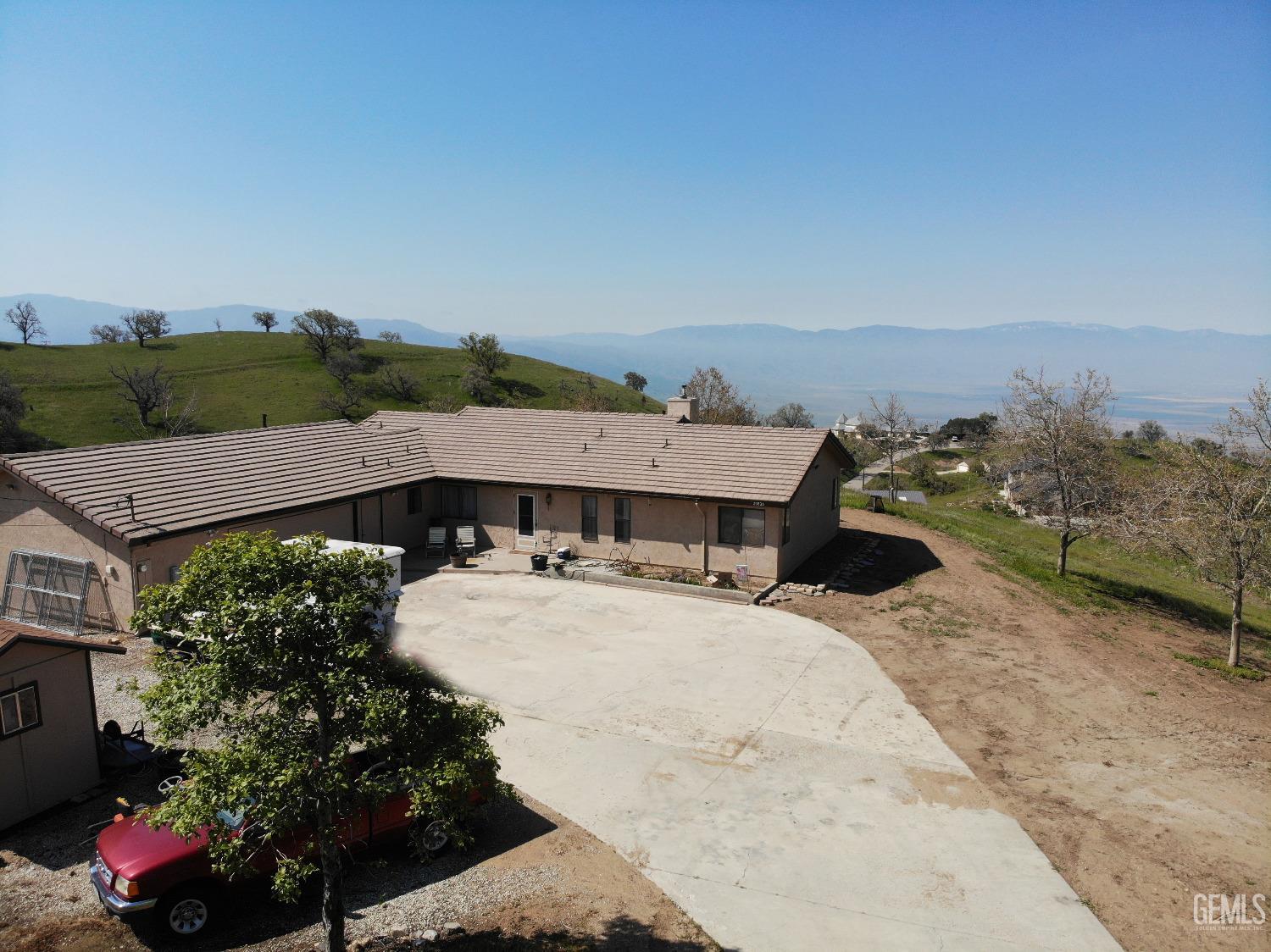 an aerial view of a house with a yard basket ball court and outdoor seating