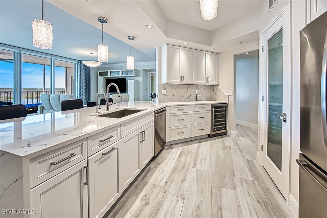 a kitchen with stainless steel appliances granite countertop a sink refrigerator and cabinets