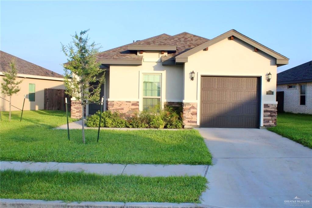 a front view of a house with a yard and garage