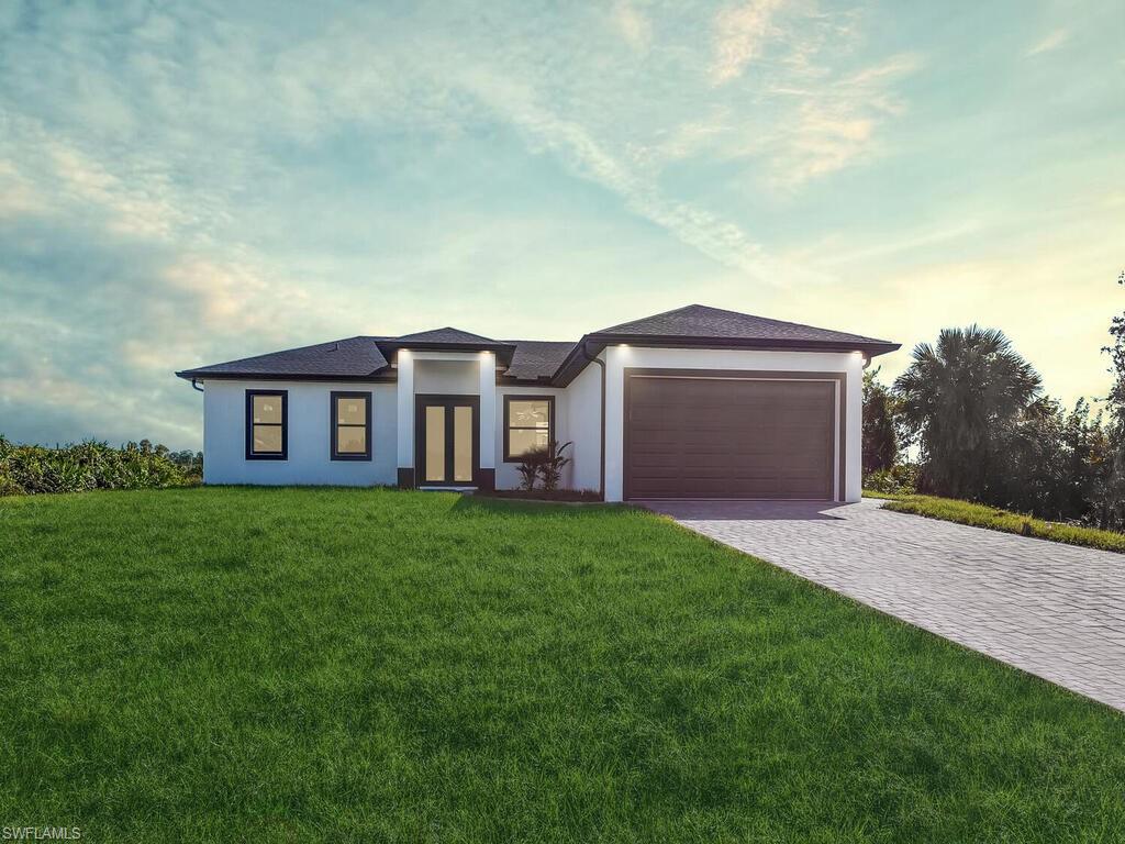 View of front of property with a garage and a lawn