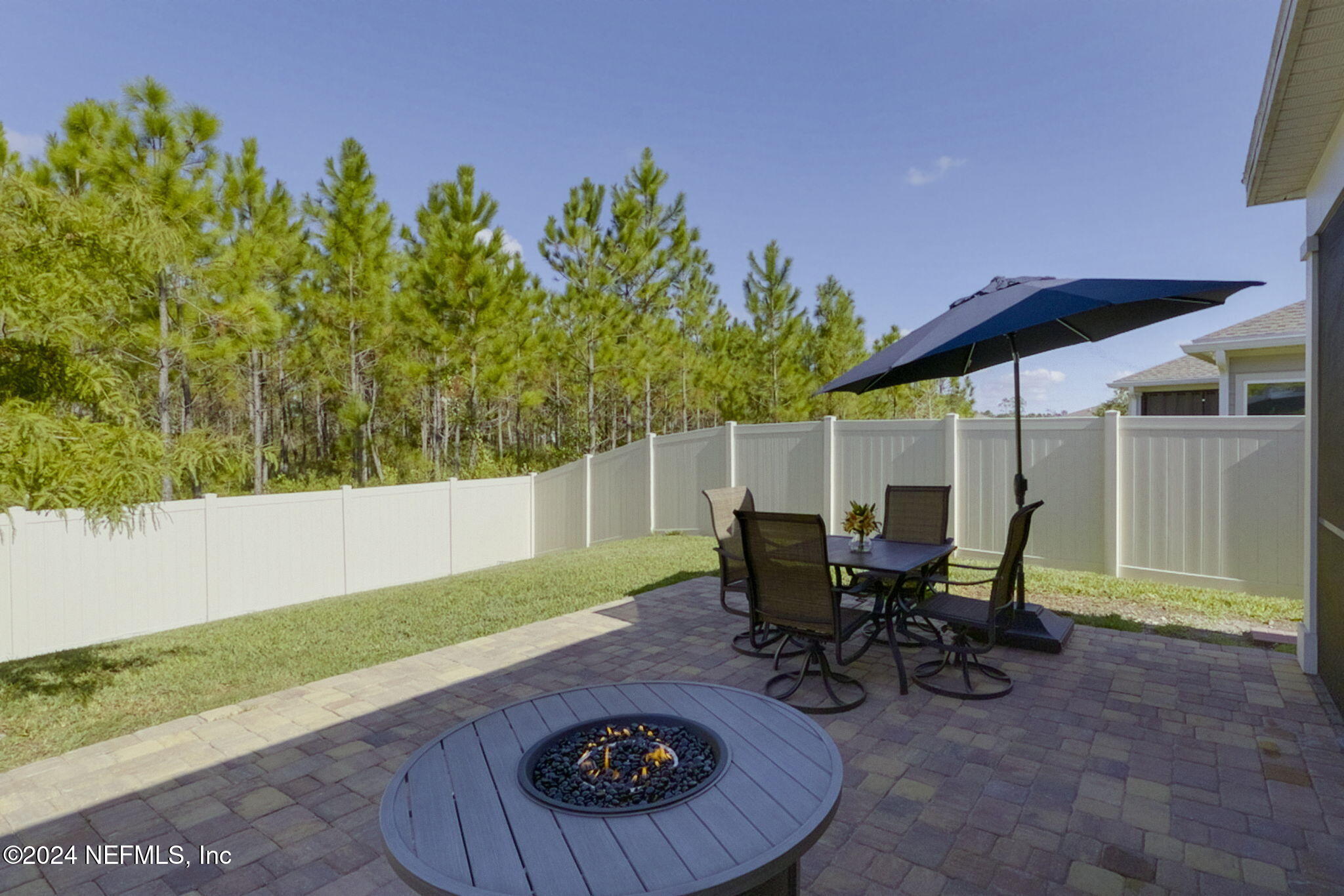 a view of a backyard with table and chairs and a yard