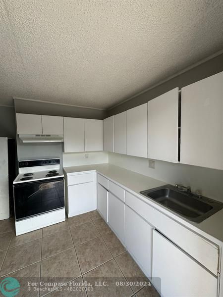 a kitchen with a stove microwave and sink