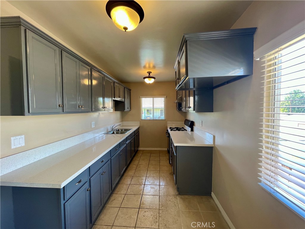 a large kitchen with a large counter top stainless steel appliances and cabinets