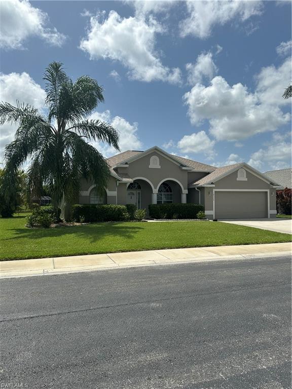 View of front of house with a front lawn and a garage