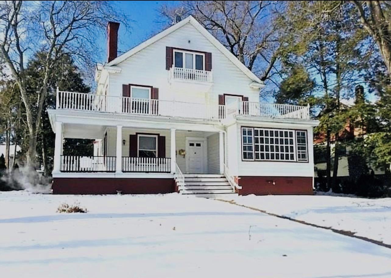 View of front of home featuring covered porch and a balcony