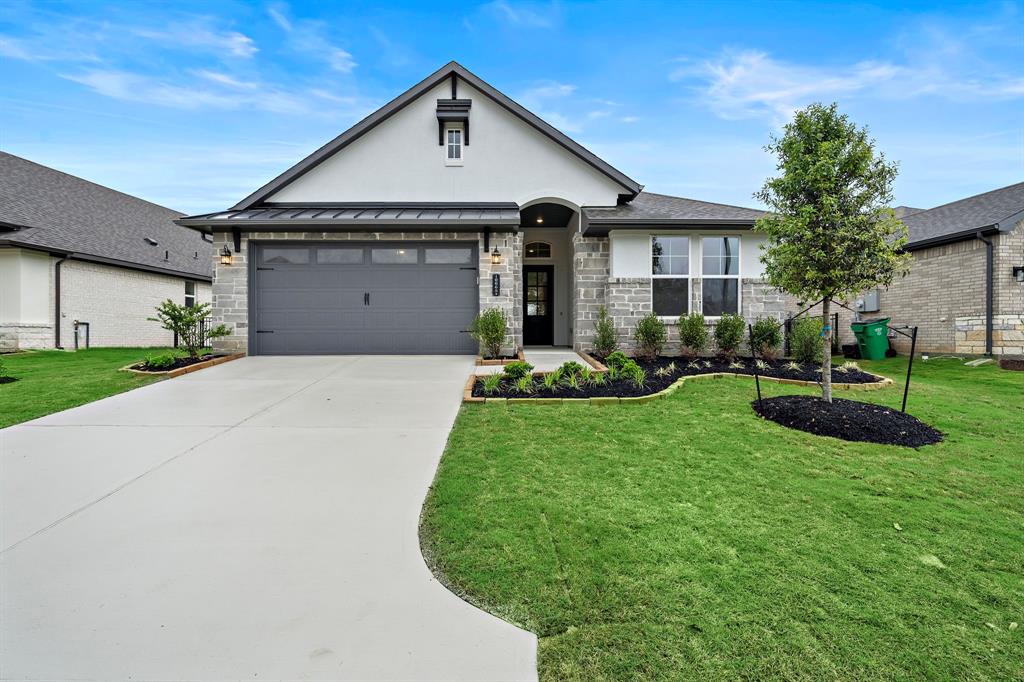 a front view of a house with a yard and garage