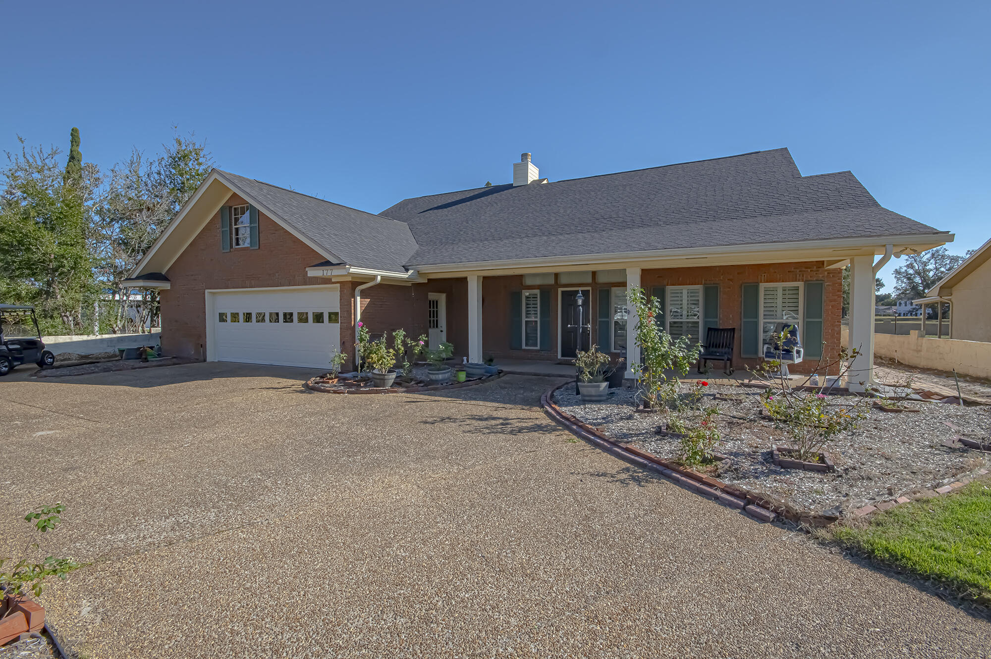 a front view of a house with porch and garden