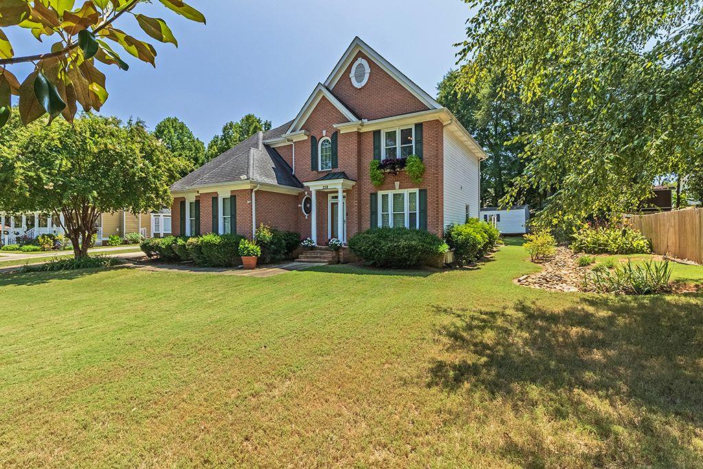 a front view of a house with a yard and trees