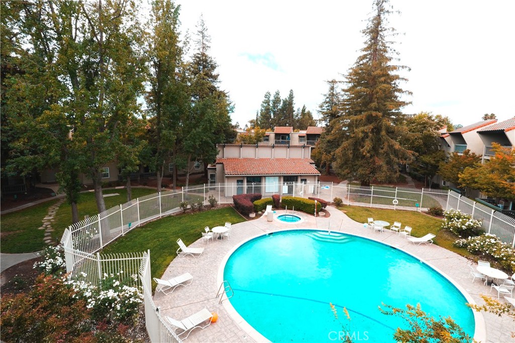 a view of a swimming pool with a patio and a yard