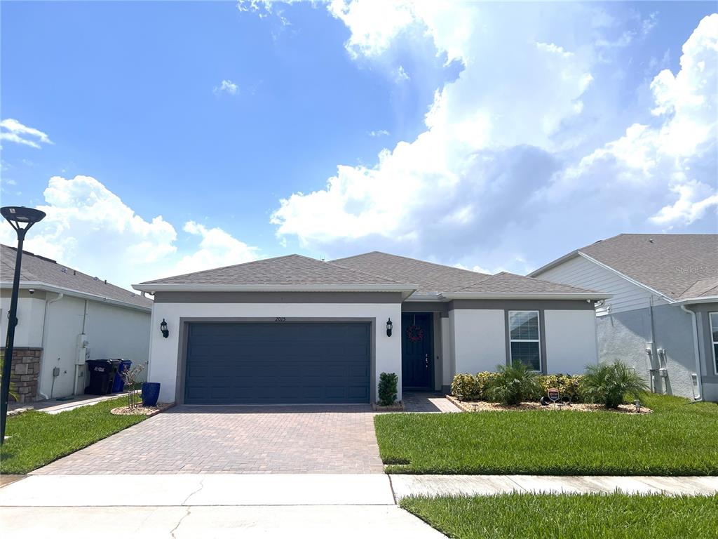 a front view of a house with a yard and garage