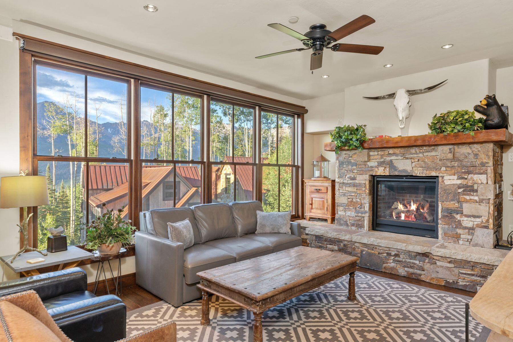 a living room with furniture a large window and a fireplace