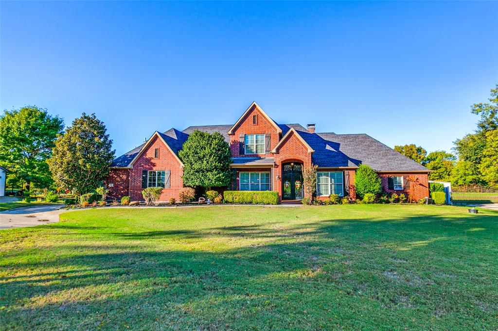 a front view of a residential houses with yard and green space