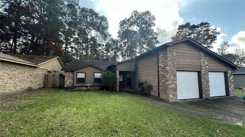 front view of a house with a yard and a large tree